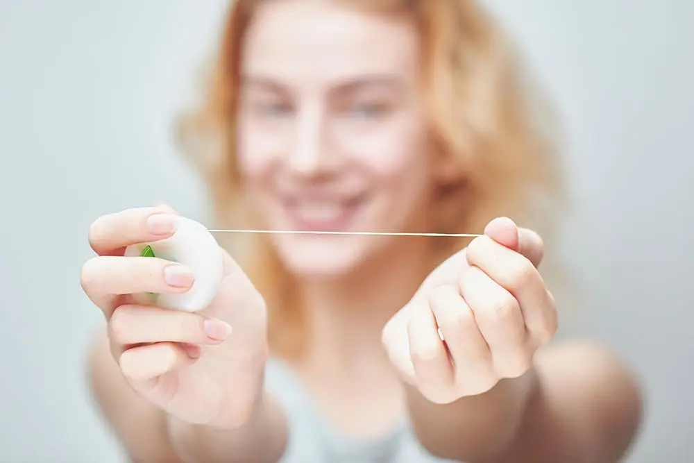 Woman holding up floss